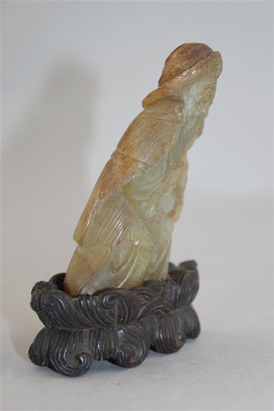 A Chinese celadon and russet skin jade figure of a fisherman, 18th / 19th century, 10cm., loss to right foot, carved wood stand